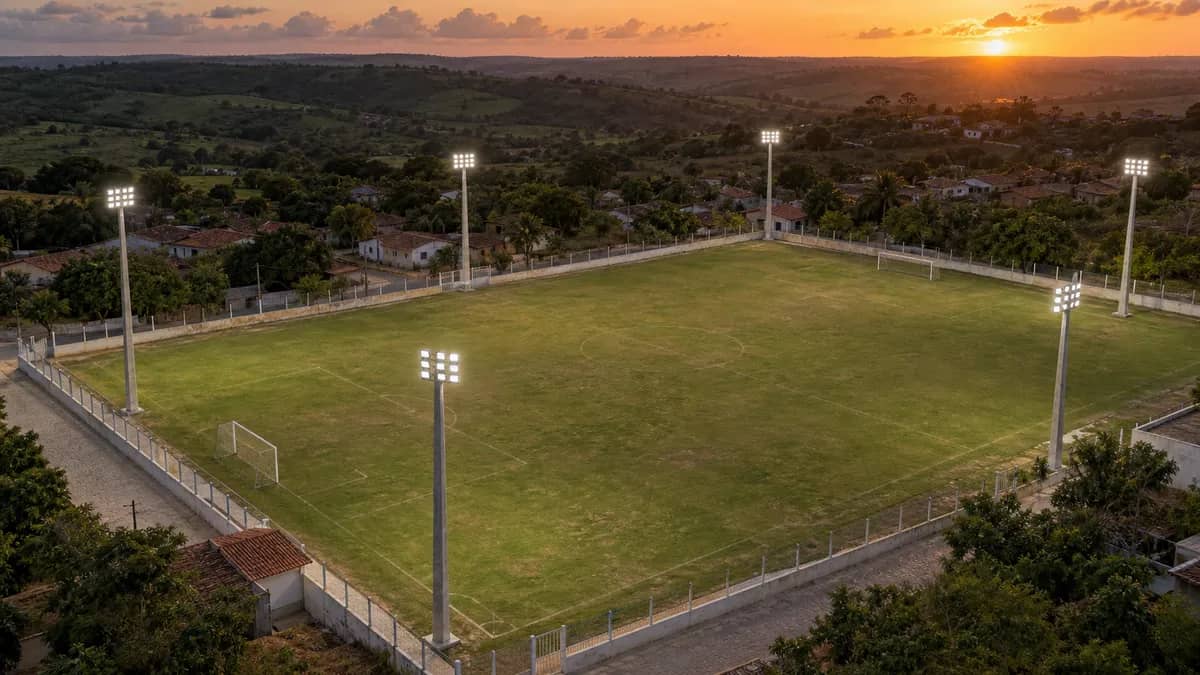 Vista aérea do Campo Aníbal ao entardecer com seis postes de iluminação distribuídos ao redor do gramado